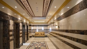 A hotel lobby with a marble floor, a patterned carpet, and a sofa. - Snood AL-Dana Hotel (Makkah)