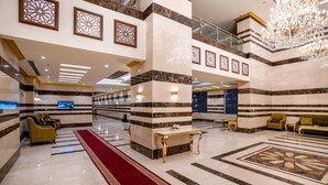 A spacious lobby with marble flooring, a red carpet, and a chandelier. - Snood AL-Dana Hotel (Makkah)