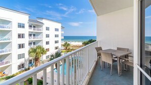 Un balcón con vista a la playa y a la piscina.