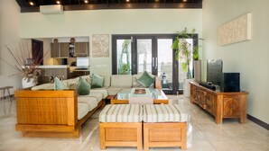 A spacious living area with a sofa set, a coffee table, and a television on a wooden cabinet. - Sunset Villa by Premier Hospitality Asia (Nusa Dua)