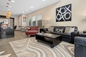 Relax in this stylish living room with a comfortable sofa, coffee table, and dining area.