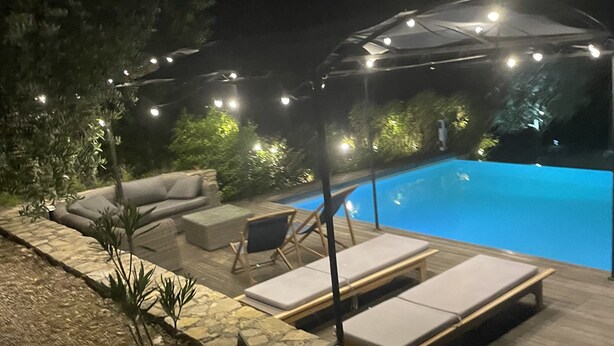 A nighttime pool area with lounge chairs and string lights. - Magnificent villa in the heart of the Var for a superb vacation. (La Verdiere)