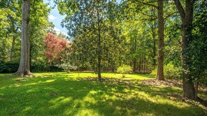 A park with a grassy area, trees, and a fence in the background. - Pet-Friendly 3BR 2BA - Fenced Yard (Durham)