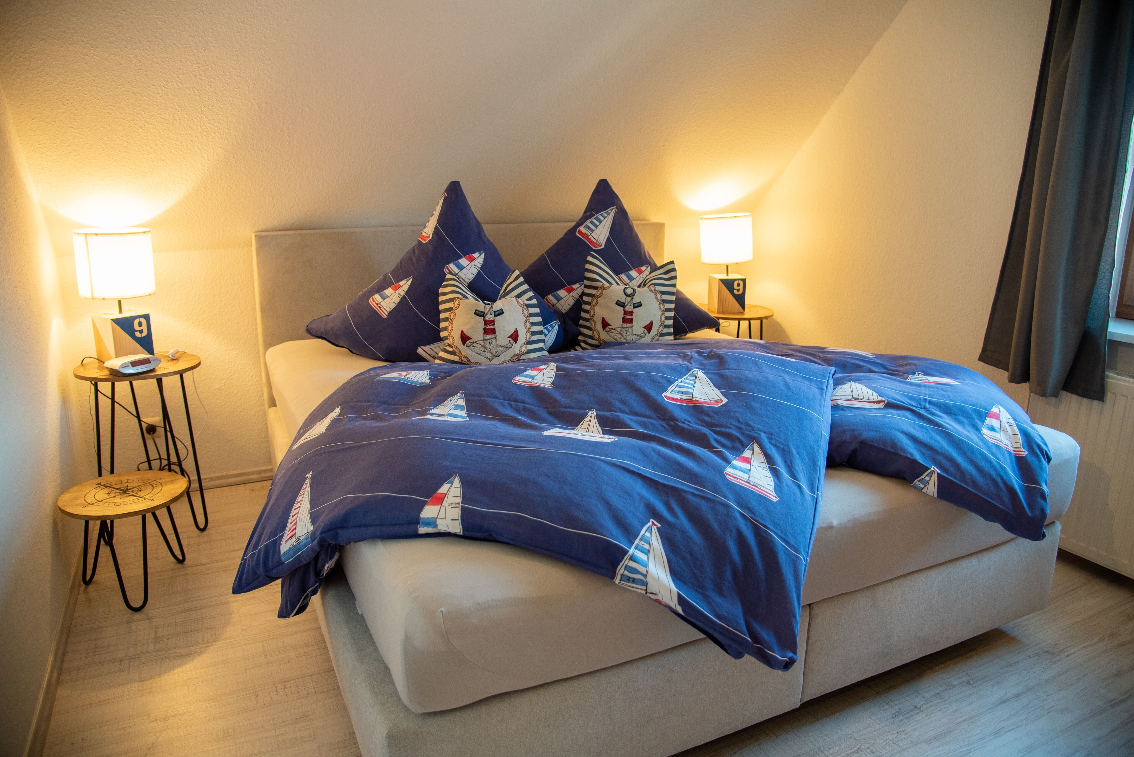 Une chambre à coucher avec un lit, deux tables de chevet et une lampe.