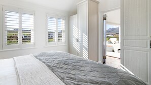 A bedroom with a bed, a window with blinds, and a view of the outdoors. - Winelands Golf Lodges 3 (Stellenbosch)