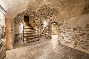A stone staircase in a building with rough walls and a tiled floor. - 'Unterlanpacher Historic Refugium' with Mountain View, Garden & Terrace (Laces)
