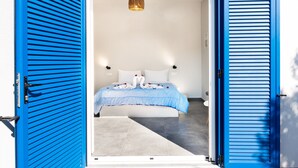 Ein Zimmer mit einem Bett, einer blauen Tür und einer Lampe.