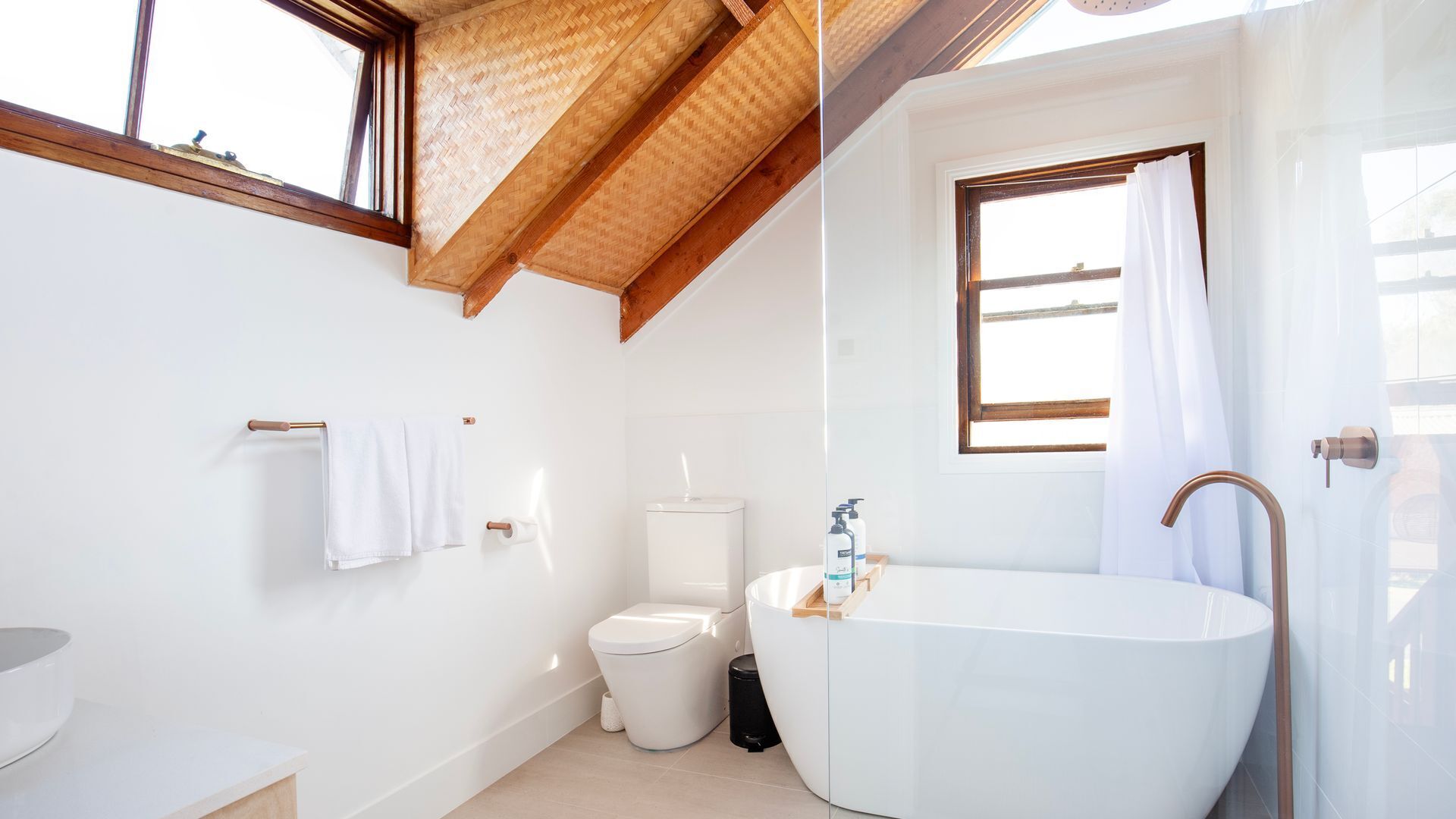 A modern bathroom with a freestanding bathtub, a toilet, and a sink.