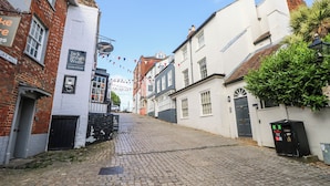 Una calle adoquinada flanqueada por edificios históricos, incluyendo un pub llamado "Jack & the Wolf".