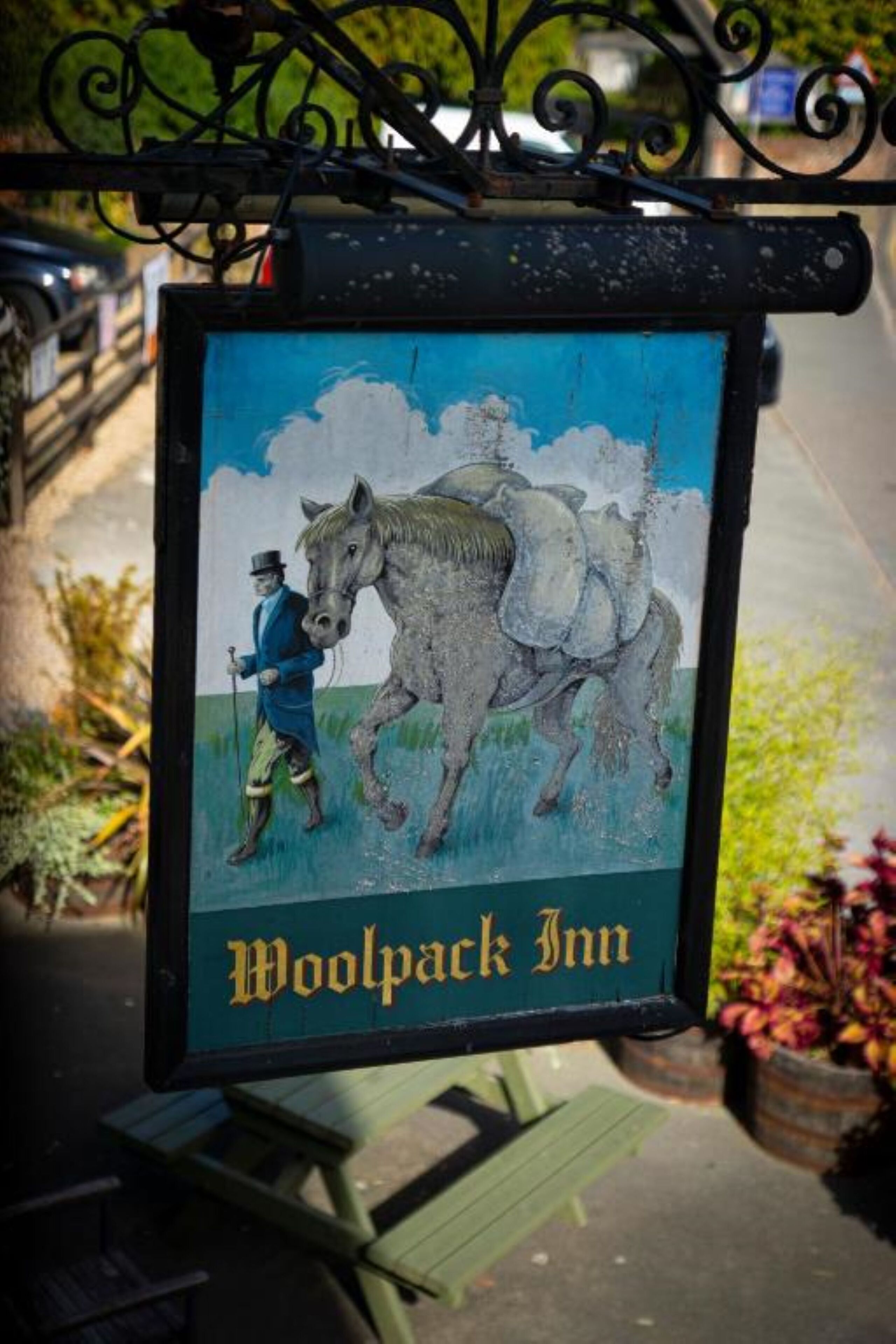 A sign for Woolpack Inn with a horse and rider illustration.