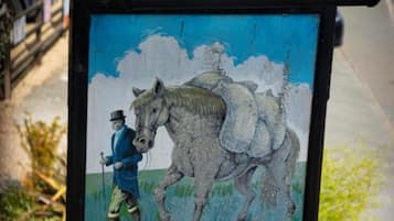 A sign for Woolpack Inn with a horse and rider illustration.