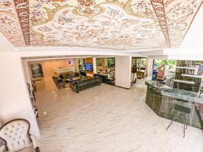 A spacious living area with a modern sofa set, a flat-screen TV, and a dining area with a glass partition. - Bir Hotel (Antalya)