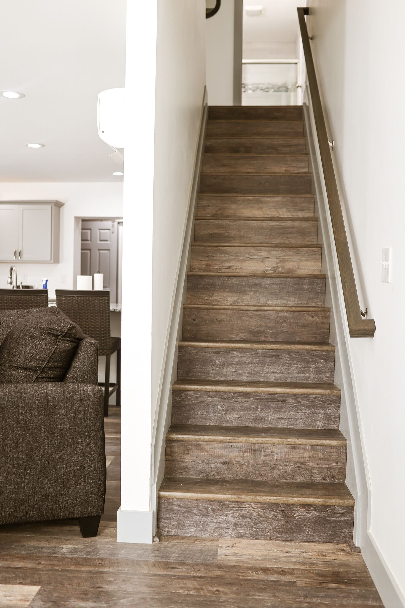 Un escalier en bois avec une rampe, menant à l’étage supérieur.