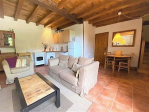 Cozy living space with a sofa, coffee table, and dining area.