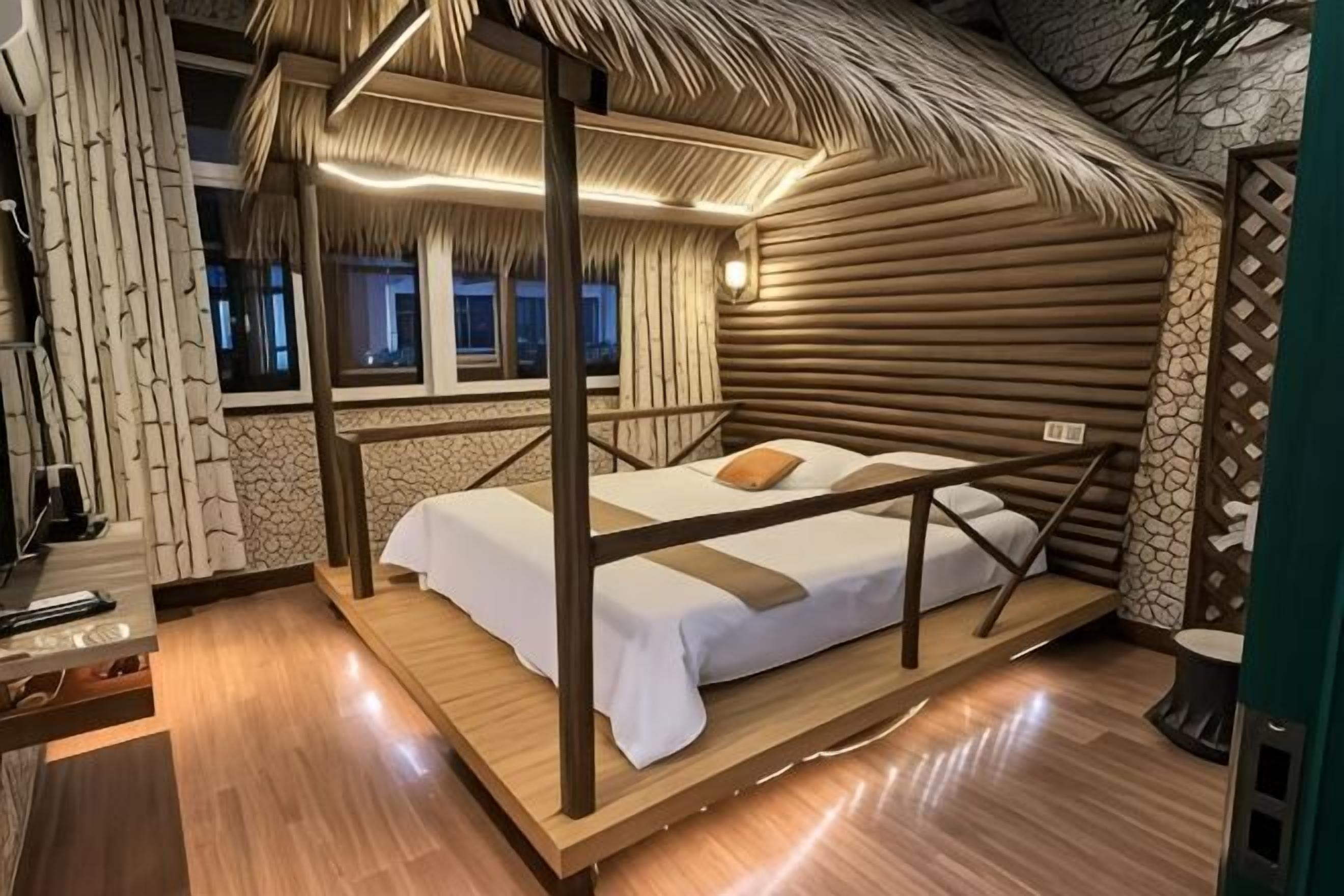 Una stanza con un letto a baldacchino, pavimento in legno, parete in pietra e una finestra con vista sull'esterno.