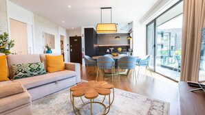 Una sala de estar moderna con un sofá, una mesa de centro y un comedor con sillas.