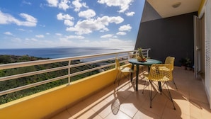 A balcony with a table and chairs, overlooking a coastal landscape. - Sea View by Atlantic Holiday (Santa Cruz)
