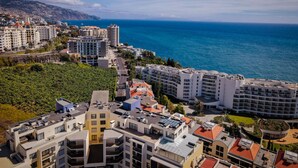 A coastal cityscape with modern buildings, a clear view of the sea, and a hilly background. - Centromar Residence Ocean View by Atlantic Holiday (Funchal)