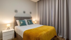 Une chambre à coucher avec un lit, des tables de chevet et des rideaux.