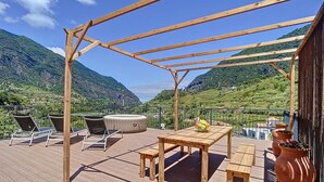 A wooden deck with lounge chairs, a round seating area, and a table with fruit. - Villa Teresa 1 by Atlantic Holiday (São Vicente)