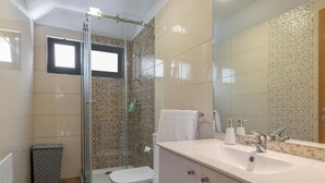 Un baño con ducha, inodoro y lavabo.