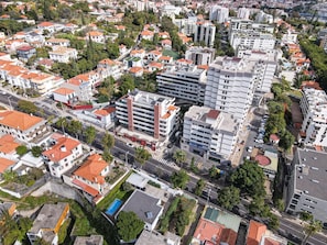 An aerial view of a residential area with a mix of single and multi-story buildings, roads, and greenery.
