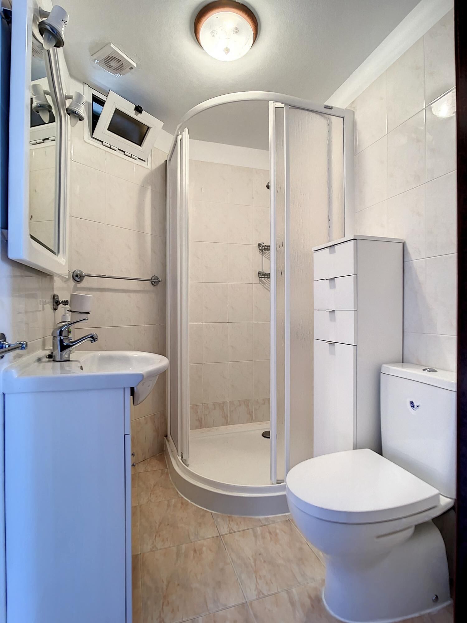 A modern bathroom with a shower, toilet, and sink.