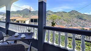 Un balcón con vistas a un pueblo y montañas.