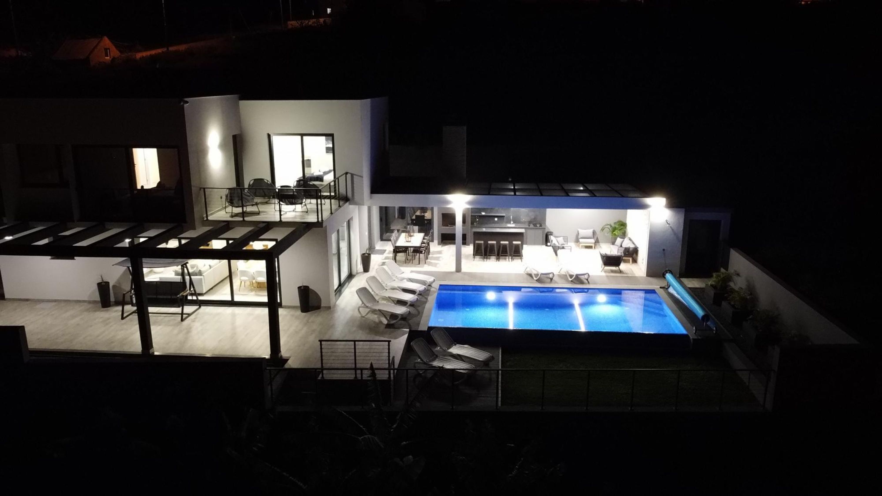 Une maison moderne dotée d’une piscine, d’un coin repas et d’un salon.