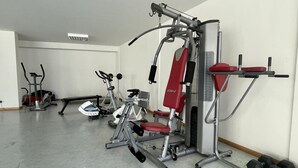 A gym with various exercise equipment including a treadmill, elliptical, and weight machines. - Terrace Apartment by Atlantic Holiday (Funchal)