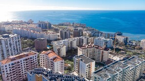 A high-rise residential building complex with multiple balconies, a central courtyard, and a view of the sea. - Terrace Apartment by Atlantic Holiday (Funchal)
