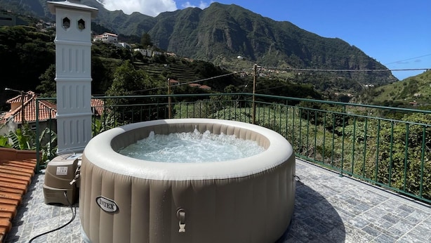Uma banheira de hidromassagem em um terraço com vista para as montanhas.