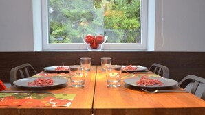A dining table set for four with plates of food, glasses, and a decorative bowl of fruit. - 5 Seasons House Zell am See - TOP 1 Summer Card (Zell am See)