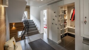 Un intérieur moderne avec un escalier, une armoire à portes vitrées et un plancher en bois.