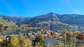 Une ville au bord d’un lac, avec vue sur les montagnes, des maisons dotées de panneaux solaires et un paysage automnal aux couleurs flamboyantes.