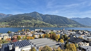 Une ville située au bord d’un lac, avec des immeubles d’habitation, une église et des montagnes en arrière-plan.