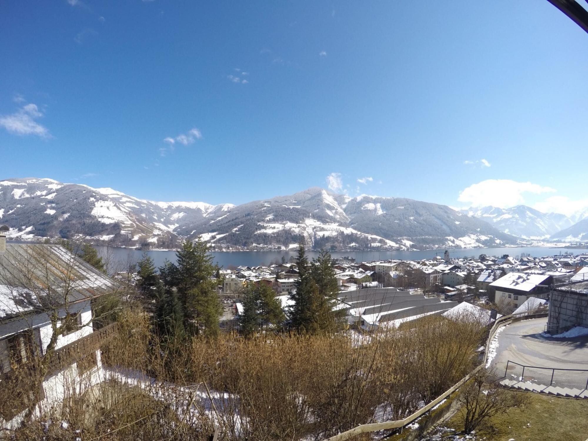 A town with snow-covered buildings and mountains in the background.