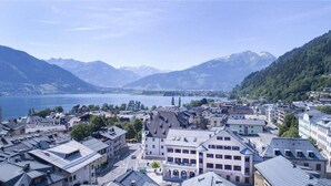 Une ville bordée de bâtiments le long d’une promenade au bord de l’eau, entourée de montagnes et d’un lac.