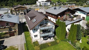 A residential area with modern houses, a prominent white building with a curved roof, and a view of mountains in the background. - Fourteen 2 1 Zell am See S P (Zell am See)