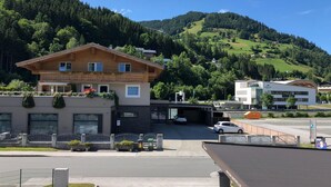 Ett hotell med en träfasad, en överbyggd entré och utsikt över ett bergigt landskap.
