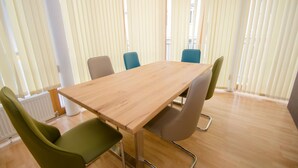 A conference room with a wooden table, four chairs, and vertical blinds. - Apartment Zell City - Next to ski Lift and Town (Zell am See)