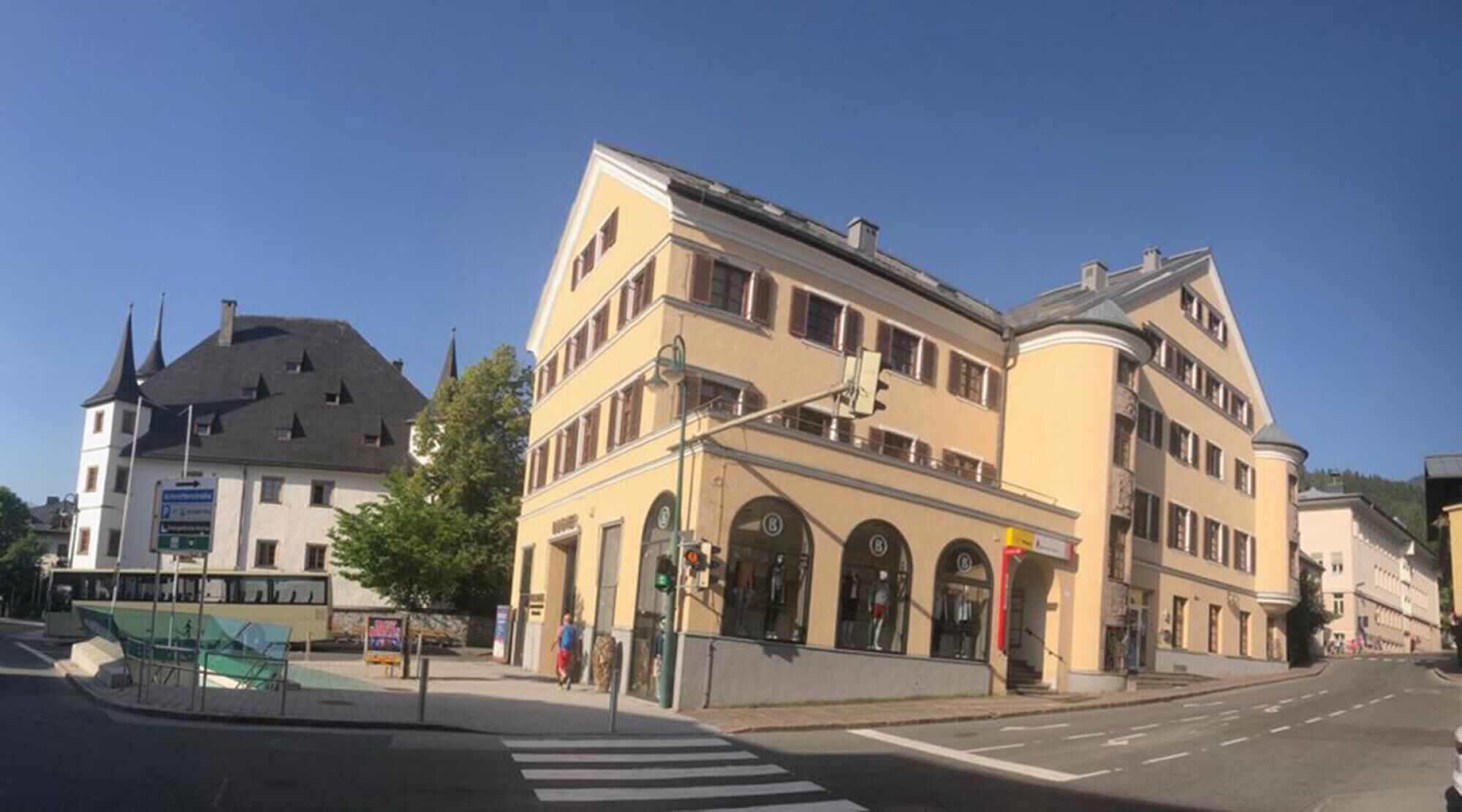 A multi-story building with a curved facade, large windows, and a corner entrance.