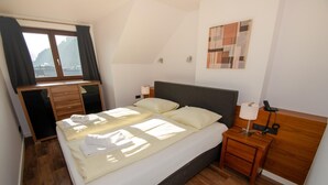 A neatly arranged hotel room with a bed, bedside tables, a desk, and a window with curtains. - Post Residence Apartments 10B Sauna Near ski lif (Zell am See)