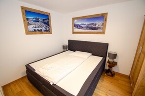 Une chambre à coucher avec un lit queen-size, deux lampes de chevet et deux tableaux encadrés accrochés au mur.