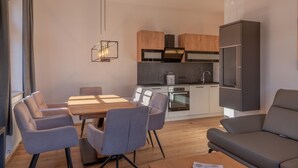 A modern kitchen with wooden cabinets, a built-in oven, and a refrigerator. - Post Residence Apartments 1C Sauna Near ski Lift (Zell am See)