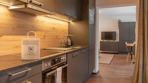 A modern kitchen with a wooden countertop, stainless steel appliances, and a built-in oven.