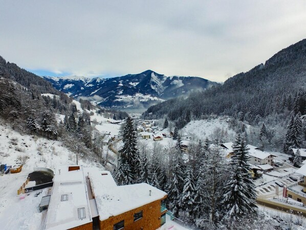 A snow-covered village with buildings, a mountain range in the background, and a valley. - Apartment Summer Winter Fun II - 200 m From ski (Zell am See)