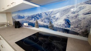 A modern kitchen with a large window displaying a snowy mountain landscape. - Apartment Summer Winter Fun II - 200 m From ski (Zell am See)