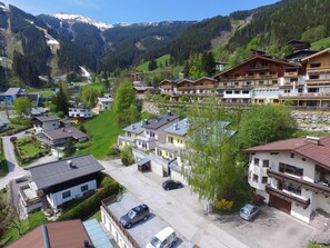 A residential area with houses, a parking lot, and a mountainous backdrop. - Apartment Summer Winter Fun II - 200 m From ski (Zell am See)