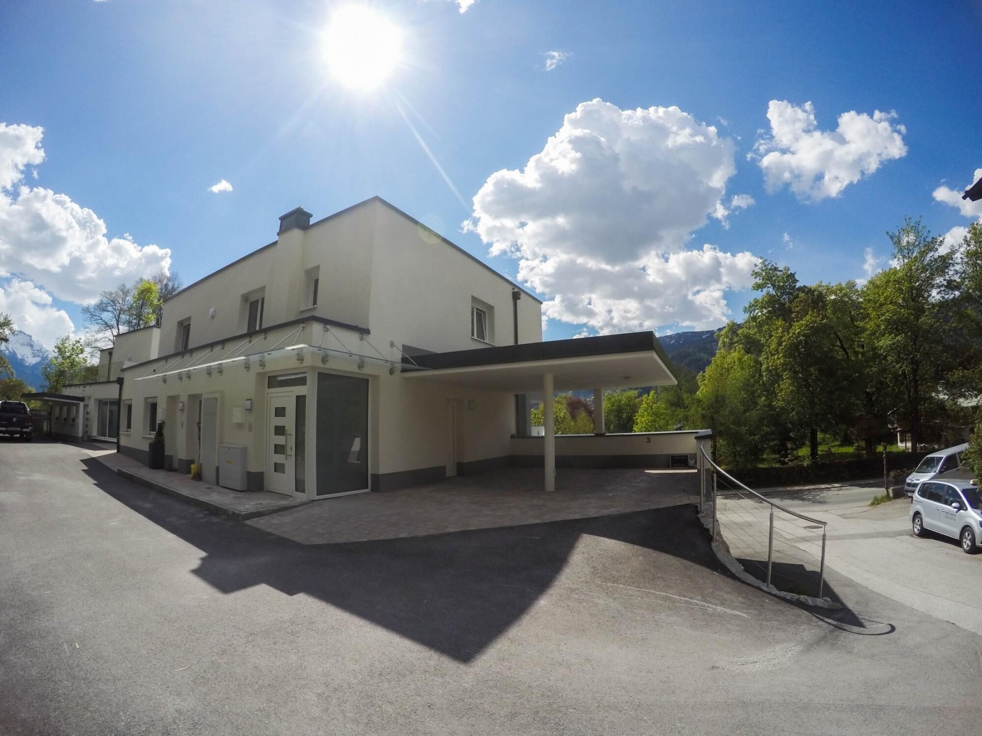 A two-story building with a flat roof and a covered entrance area.